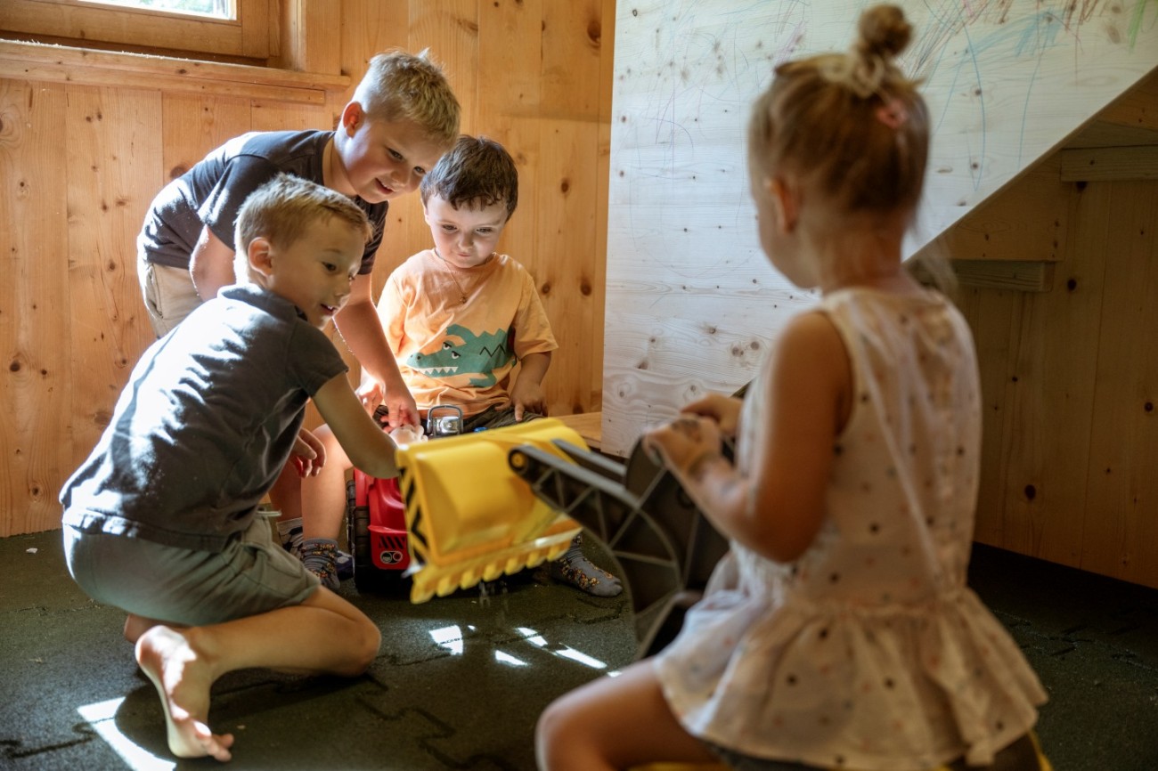 Kinder spielen mit Spielzeugauto und Bagger im Kinderhaus des Hotel Bachschmied.