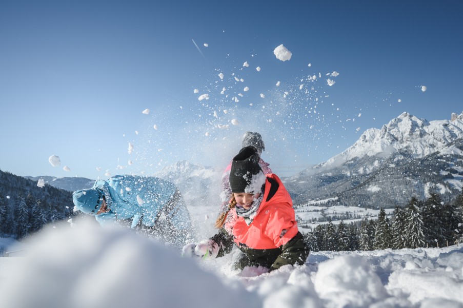 Kinder spielen im Schnee im Winterurlaub im Hotel Bachschmied. © Hochkönig Tourismus GmbH